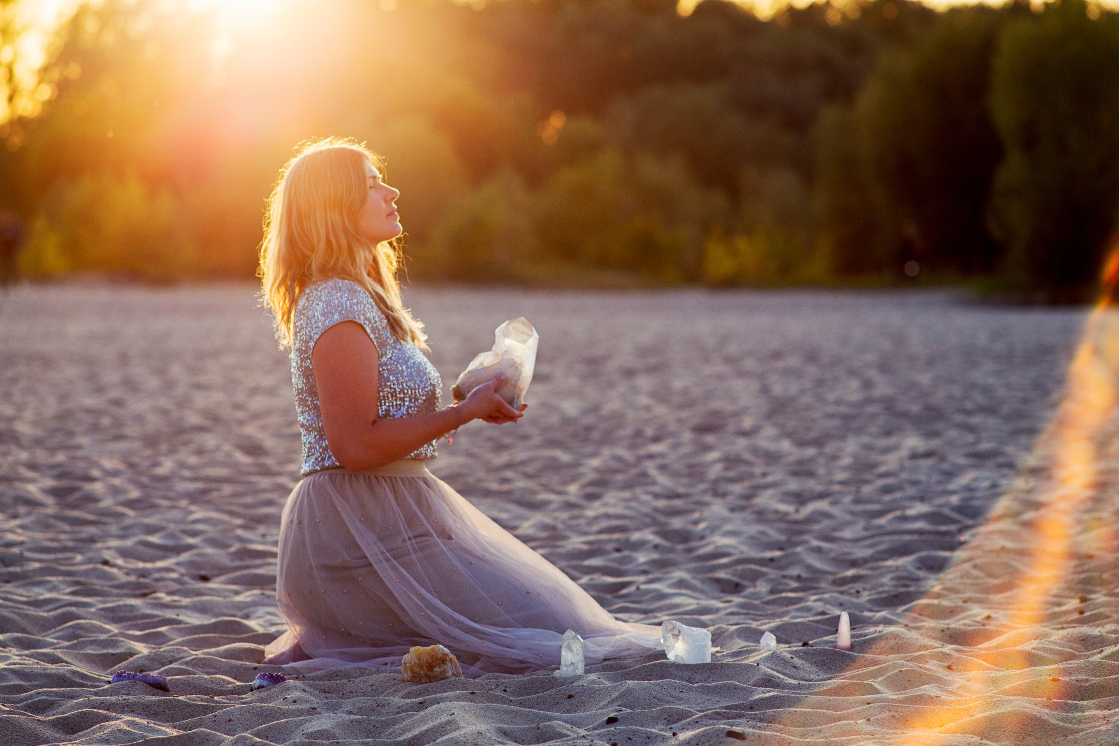 Beautiful woman on beach holding healing crystals